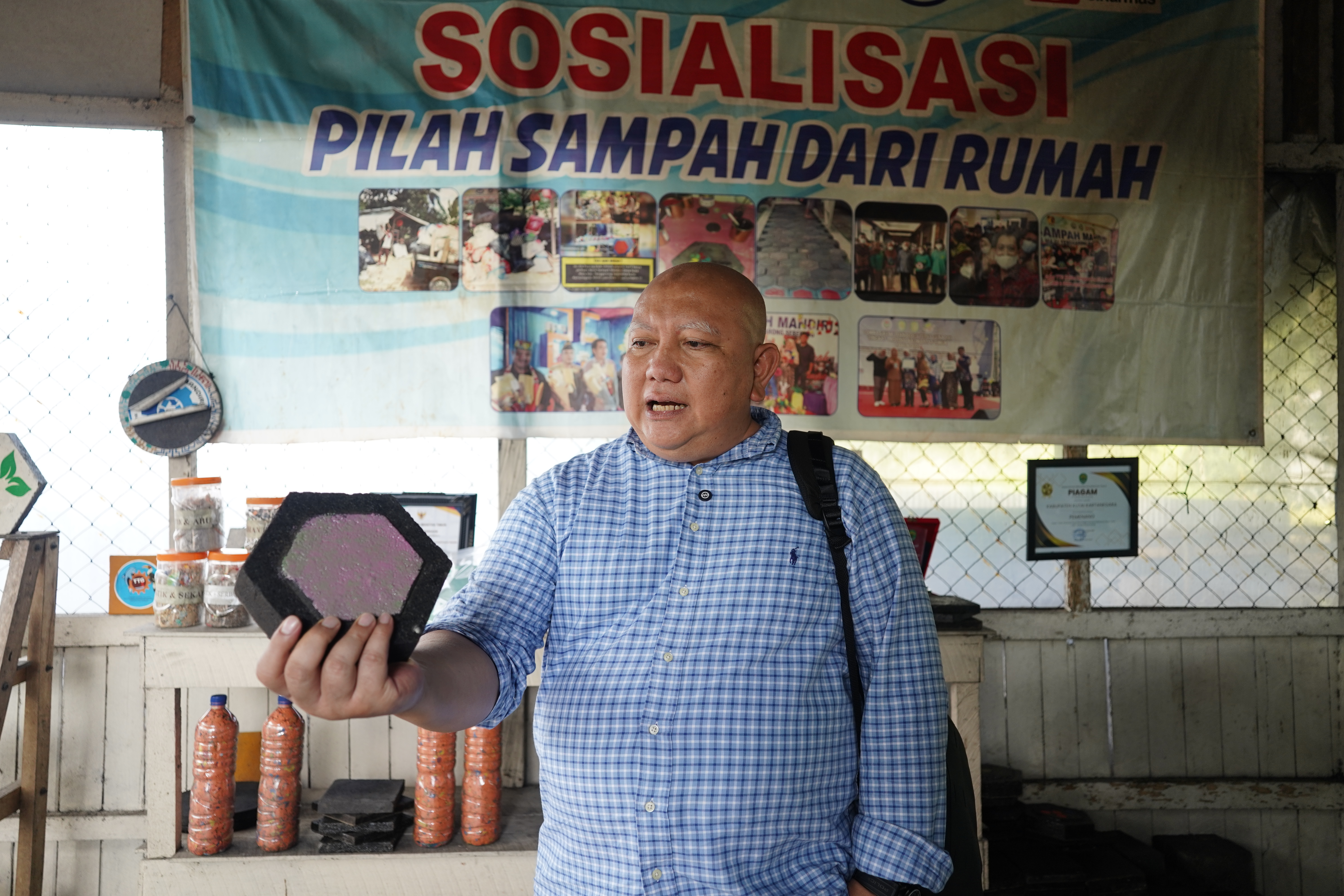 Ketua Pembina Yayasan Mitra Hijau, Dicky Edwin Hindarto menunjukkan hasil produk olahan limbah plastik yang telah dicetak dalam bentuk paving block di Bank Sampah Melati Berseri, Samarinda.